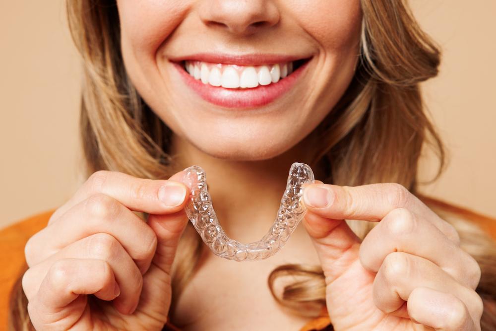 woman holding clear aligners 